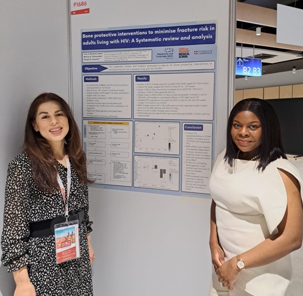 Two women with academic poster between them